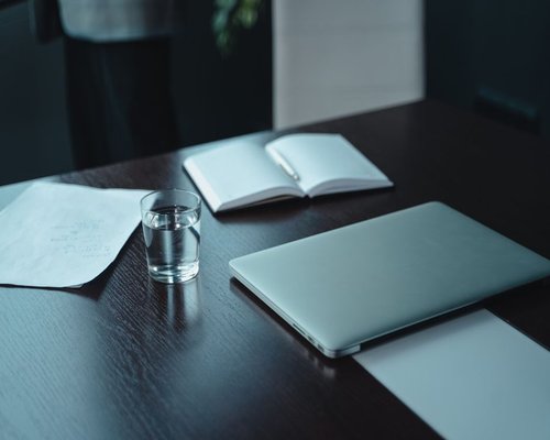 organized work desk with water and natural light